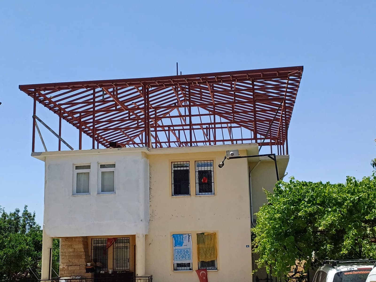 İki katlı binanın üzerinde ızgara düzeninde çelik çatı kafesi
